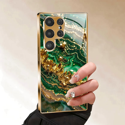 Guldpläterat mobilskal i härdat glas, kompatibelt med Galaxy S26, S25, S24, S23 och S22 Ultra Plus. Har ett texturerat mönster i grönt guld.